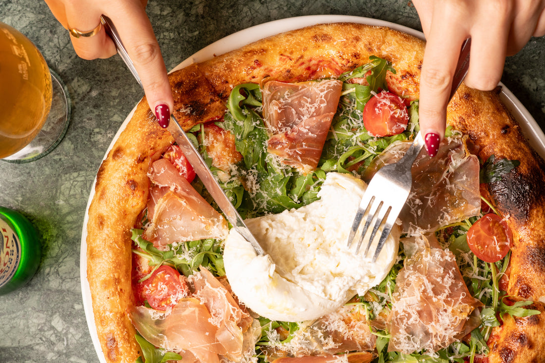 A pizza topped with Parma ham, rocket and burrata at Fiena, King's Cross
