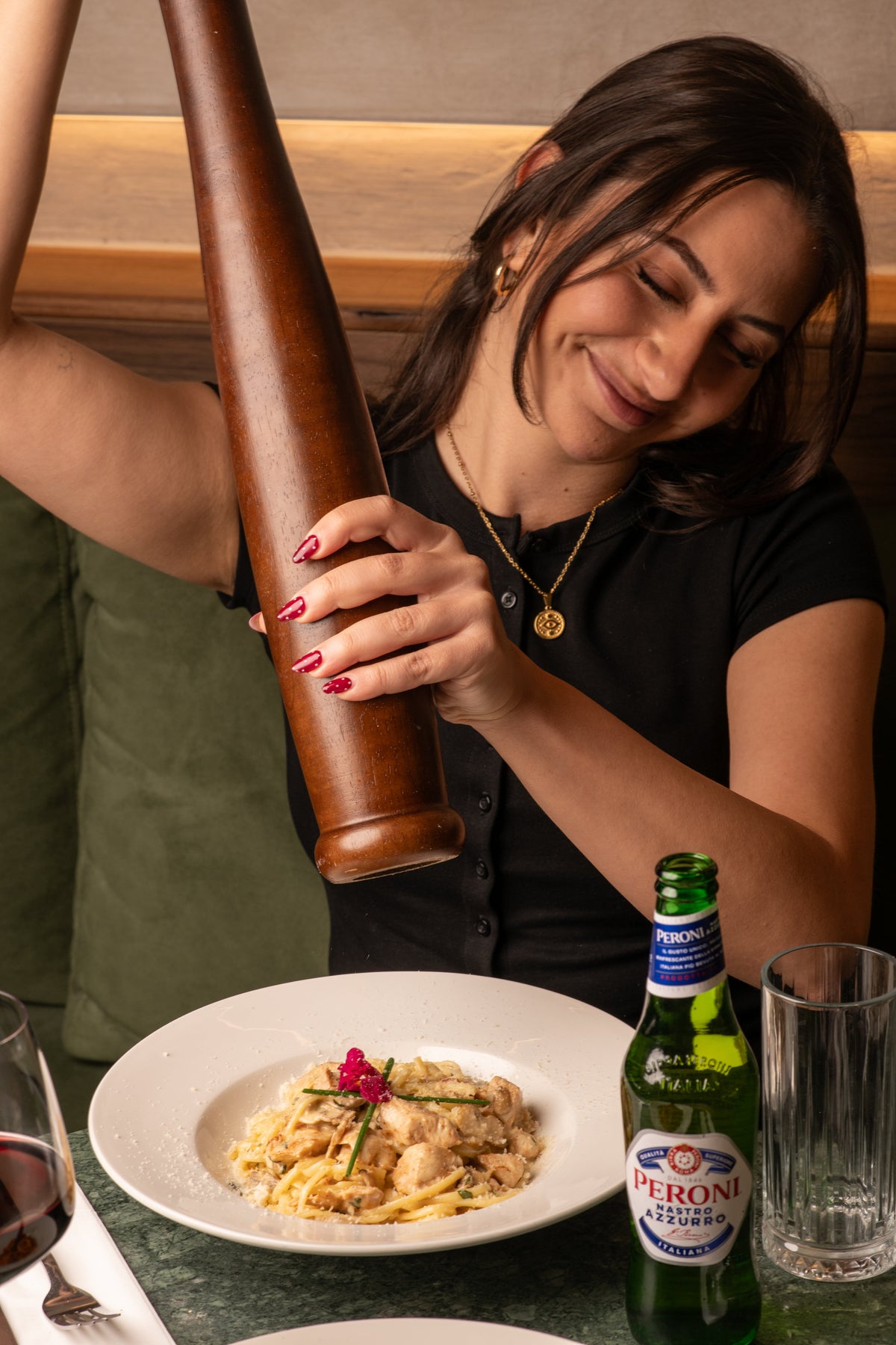 A server grinding black pepper over a creamy pasta dish at Fiena, King's Cross