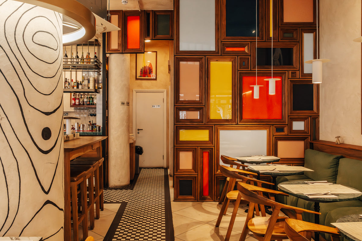 The bar at Fiena with its colourful framed-panel wall and checkerboard floor